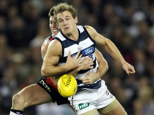 Lenny Hayes wraps up Joel Selwood. The Sainst (84) and Cats (68) combined for 152 tackles in their brutal clash.