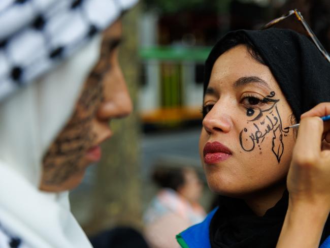 Tasnim Mahmoud Sammak has writing applied to her face in preparation for a pro-Palestinian rally in Melbourne. Picture: Getty Images