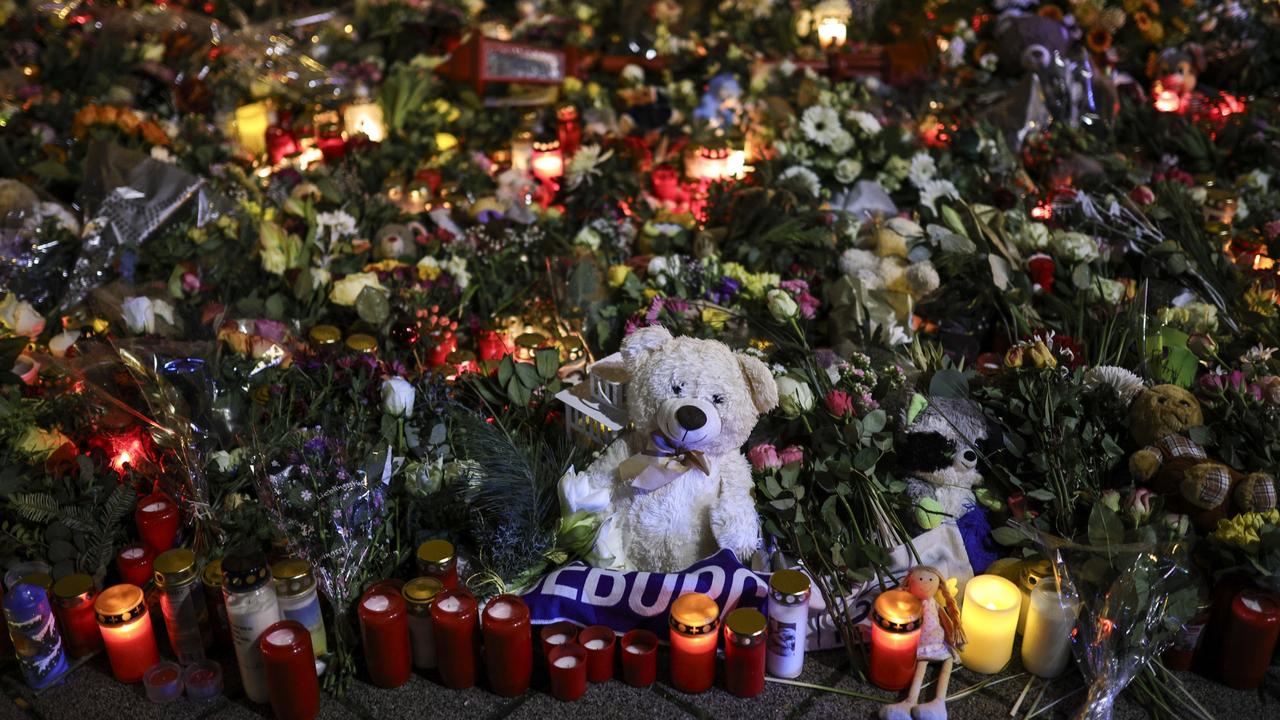 A teddy bear laid among flowers and candles outside the Johanniskirche church. Picture: Omer Messinger/Getty