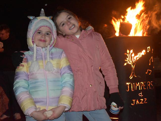 Savannah and Zaharah Herbert in front of the Jumpers-and-Jazz-themed fire sculpture at the 2021 Killarney Bonfire Night.