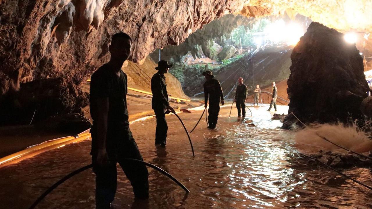 Thai rescue teams arrange water pumping system at the entrance to the flooded cave complex in Mae Sai. Picture: Royal Thai Navy via AP