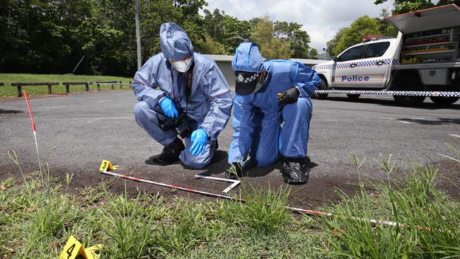 Cairns police Scenes of Crime officer Acting Sgt Wayne Boniface photographs a tyre tread mark in dirt with the help of scientific officer Sgt Vanessa Lobegeier at a simulated crime scene training exercise at Woree. Picture: Brendan Radke