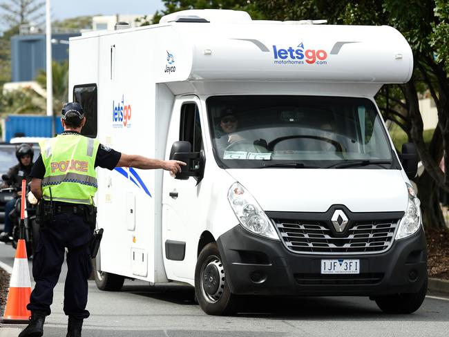 Police direct a vehicle with Victorian licence plates into a checkpoint at the Queensland border with NSW. The NT has effectively banned Victorian travellers from the NT when its borders reopen on Friday. A decision on whether a similar ban will affect New South Wales travellers is likely to be made on Wednesdday. Picture: Matt Roberts