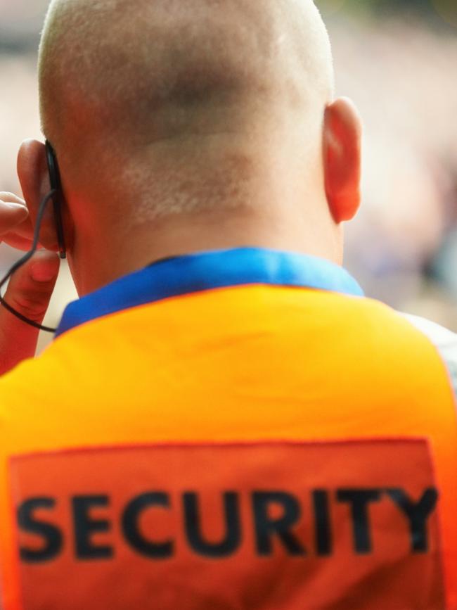 Rear view of a security guard listening to his headset. Generic photo of security guard.