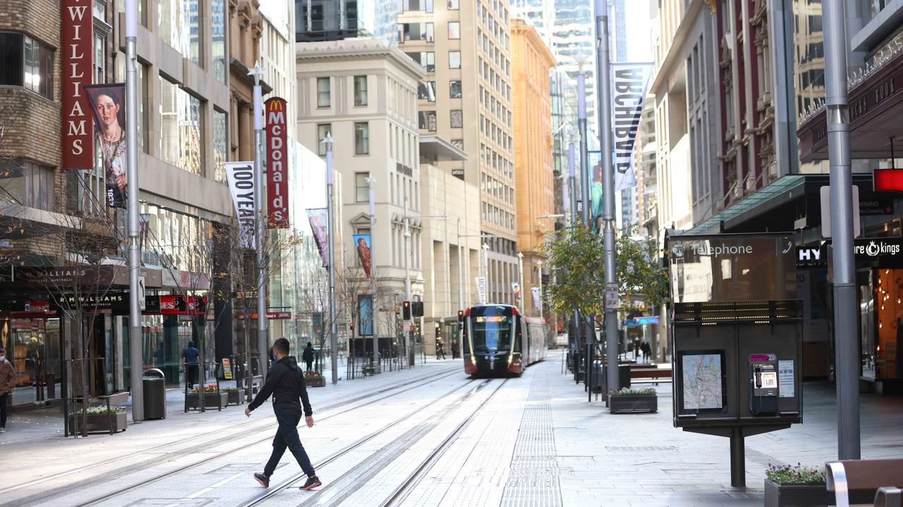 People walk on George Street in a virtually empty Sydney CBD on Saturday. Picture: Damian Shaw