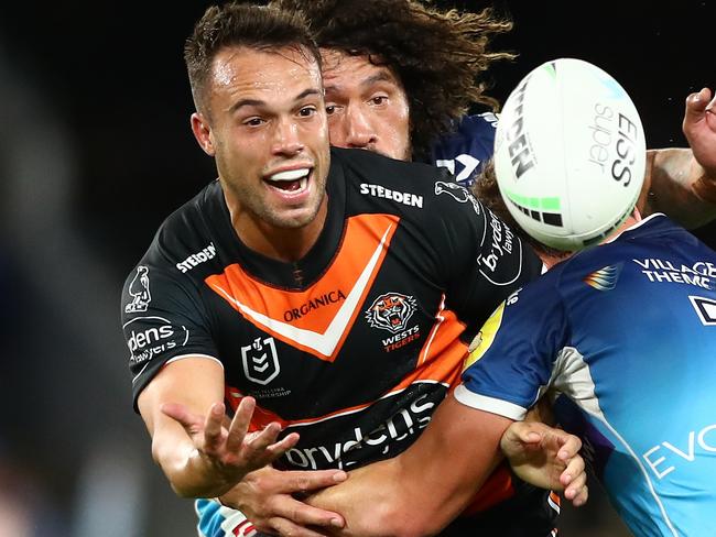 GOLD COAST, AUSTRALIA - MARCH 31: Luke Brooks of the Tigers is tackled during the round four NRL match between the Gold Coast Titans and the Wests Tigers at Cbus Super Stadium, on March 31, 2022, in Gold Coast, Australia. (Photo by Chris Hyde/Getty Images)