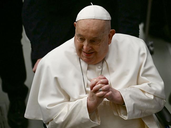 Pope Francis greets people at the end of the weekly general audience on February 12, 2025 at Paul-VI hall in The Vatican. (Photo by Filippo MONTEFORTE / AFP)