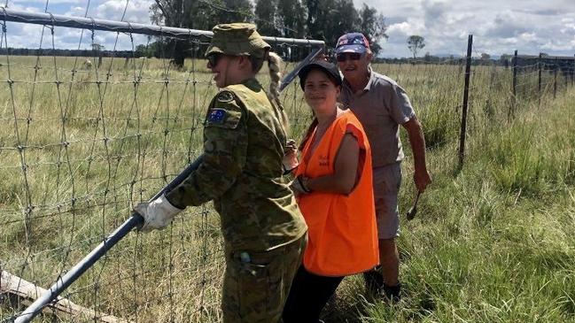 ADF Corporal Rebecca Barry with a BlazeAid volunteer helping farmer Gordon Carter at Casino.