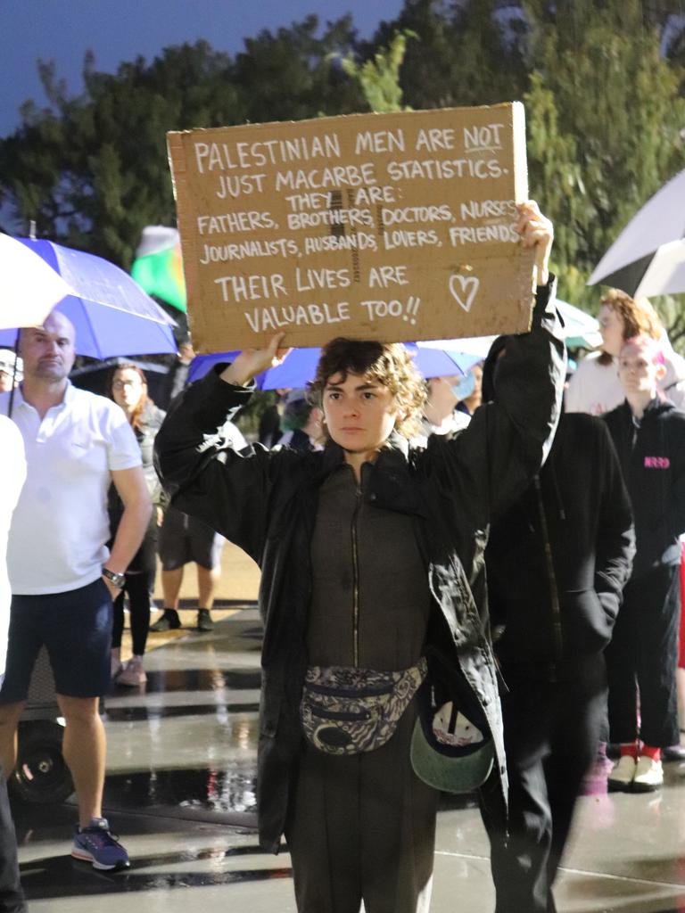 Protesters gathered at Surfers Paradise Esplanade despite torrential rain to call for an immediate ceasefire of bombing in the Gaza Strip. Picture: Amaani Siddeek