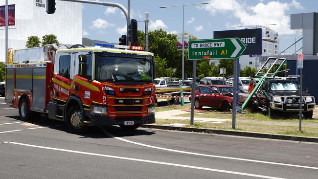 Queensland Fire and Emergency Services (QFES) personnel attend a single vehicle traffic crash at the intersection of Sheridan and Florence Streets, Cairns City, where an early model Toyota Camry struck a street sign and a parked ute. Picture: Brendan Radke