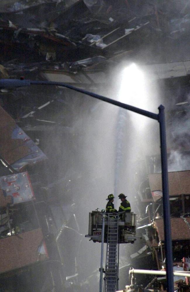 Firemen pour water on the rubble of the collapsed buildings on September 11 in New York. Picture: Nathan Edwards