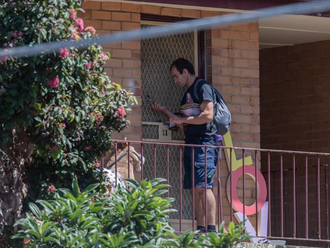 A man receives what appears to be an order from the cut-out hole in the door last month. Picture: Jason Edwards