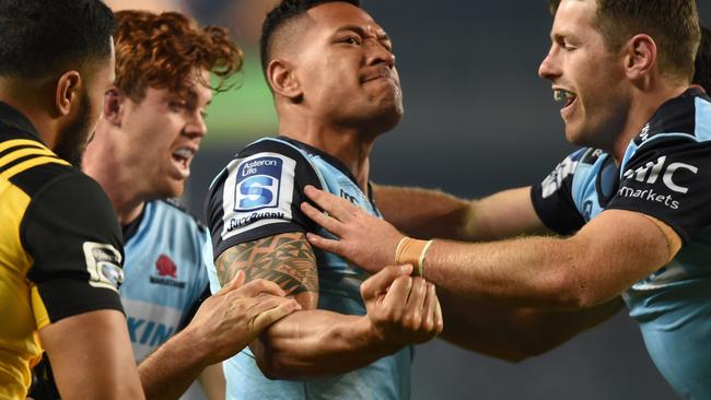 Waratahs star Israel Folau celebrates scoring against the Hurricanes on Saturday night.