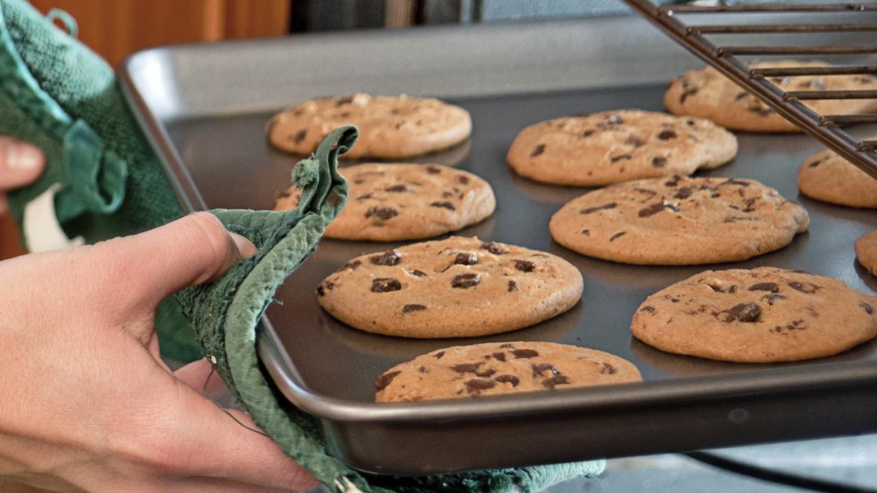 A woman pulls fresh baked cookies - not containing human ashes - from the oven.