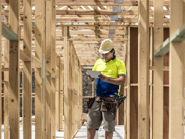 Developing Queensland - Construction worker on construction site, using digital tablet. He is checking if everything is ok.