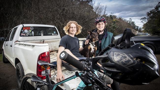 Mountain bikers Dan Booker (left) and friend Baxter Maiwald with his dog Gnala (correct) finish their ride up the mountain at the bottom of Old Farm Road, South Hobart. Picture: LUKE BOWDEN