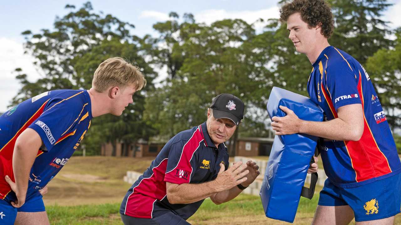 ON BOARD: Downlands rugby players Ned Williams (left) and Mick Ryan run through a tackling drill with defensive coach Graham Herlihy. Picture: Kevin Farmer