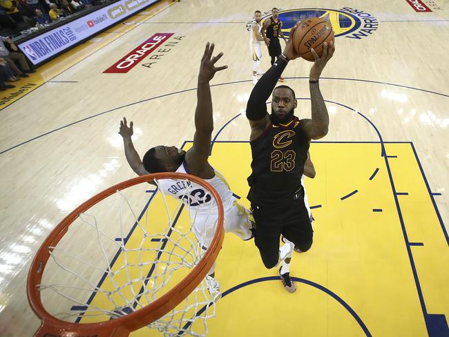 Cleveland Cavaliers forward LeBron James, right, shoots against Golden State Warriors forward Draymond Green during the second half of Game 1 of basketball's NBA Finals in Oakland, Calif., Thursday, May 31, 2018. The Warriors won 124-114 in overtime. (Ezra Shaw/Pool Photo via AP)