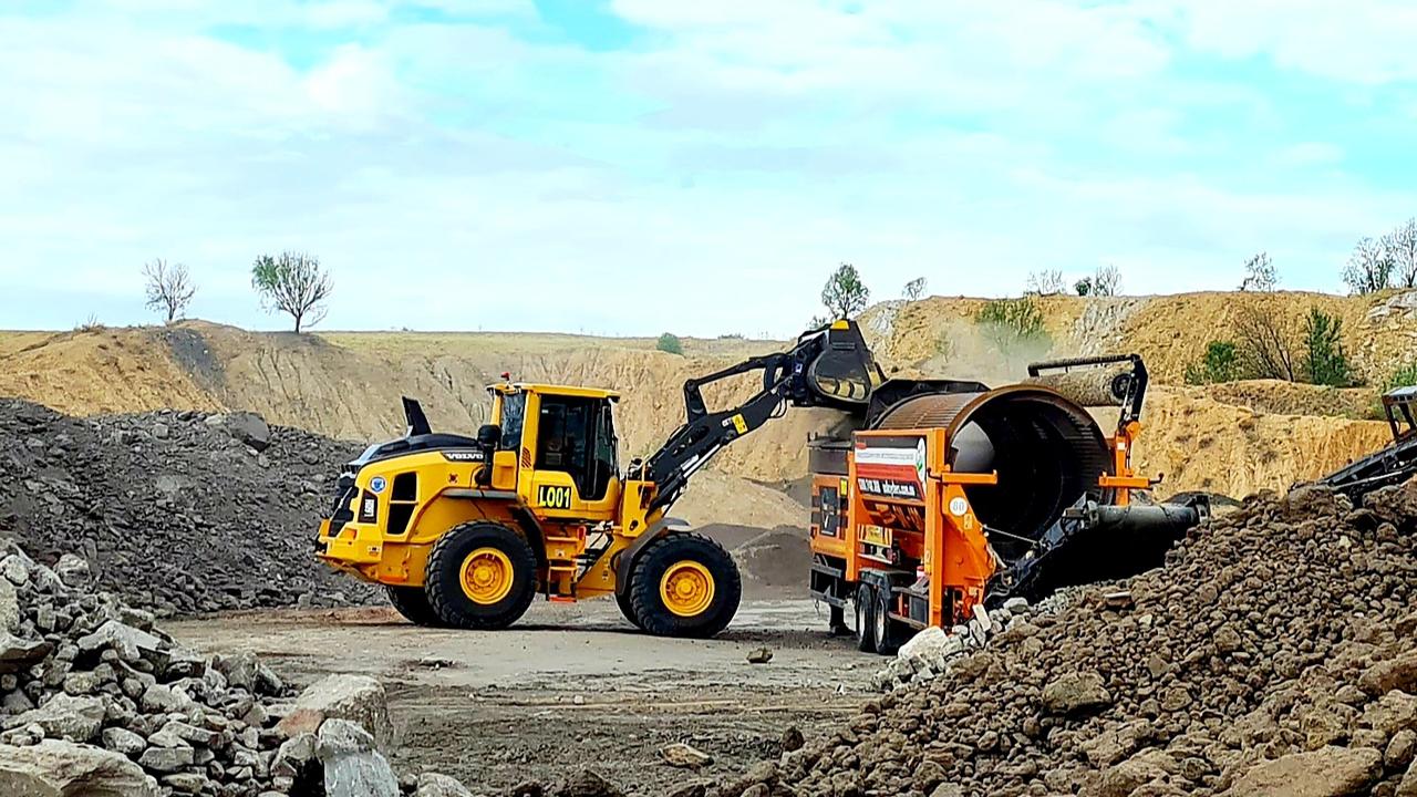 A loader feeds mine overburden into the trommel to create topsoil at the Ensham mine. Picture: Contributed