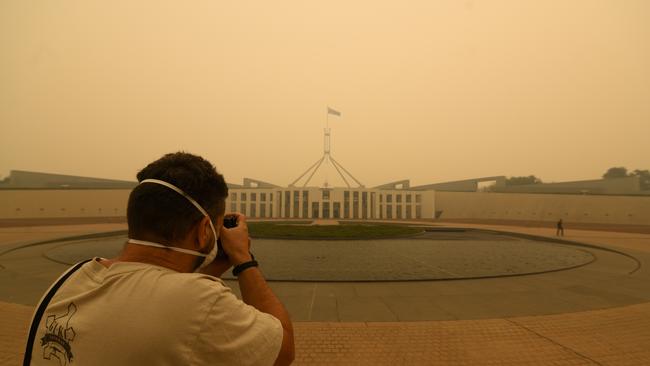 A photographer captures smoke at Parliament House. Picture: Getty