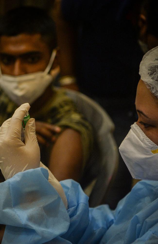 A health worker prepares to inoculate a man with a coronavirus vaccine at a camp set up in a market association's office in Siliguri. Picture: Diptendu DUTTA / AFP.