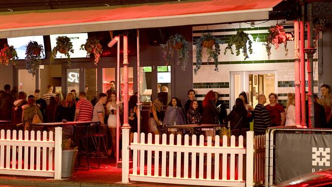 People line up to get into nightclubs, while outdoor dining furniture combines to cause congestion on footpaths along Hindley Street.