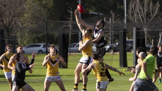 Brighton’s Hayden Kanisauskas taps the ball with Tom Bateman behind during the Bombers’ round seven Adelaide Footy league clash against Adelaide University. Brighton one by a thrilling one point. Picture: Emma Brasier