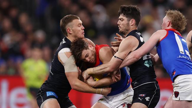 Jack Viney of the Demons is gang tackled by Patrick Cripps and George Hewitt of the Blues. Picture: Michael Klein