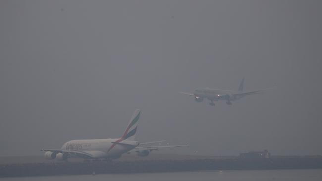 Planes landing at Sydney Airport were barely visible through the haze. Picture: John Grainger