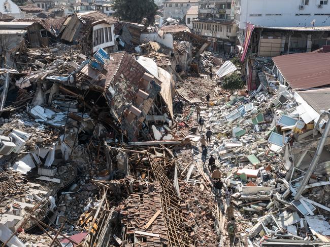 People walk past collapsed buildings in Hatay, Turkey. Picture: Getty Images