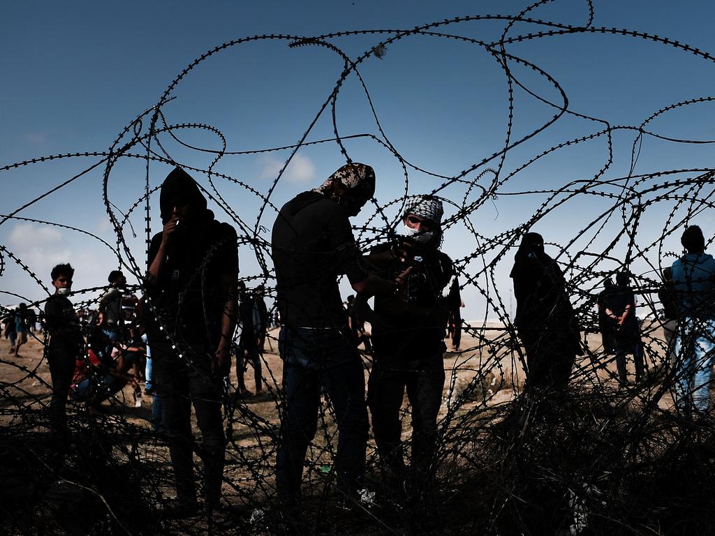 Palestinian youth pull away a section of the border fence with Israel as mass demonstrations at the fencein Gaza City, Gaza. Picture: Getty