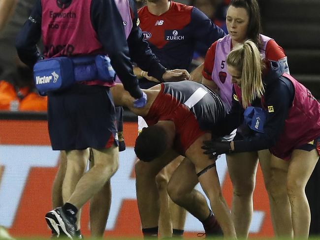 MELBOURNE, AUSTRALIA - MARCH 08: Steven May of the Demons leaves the field with trainers during the AFL Community Series match between the Western Bulldogs and the Melbourne Demons at Marvel Stadium on March 08, 2021 in Melbourne, Australia. (Photo by Daniel Pockett/Getty Images)