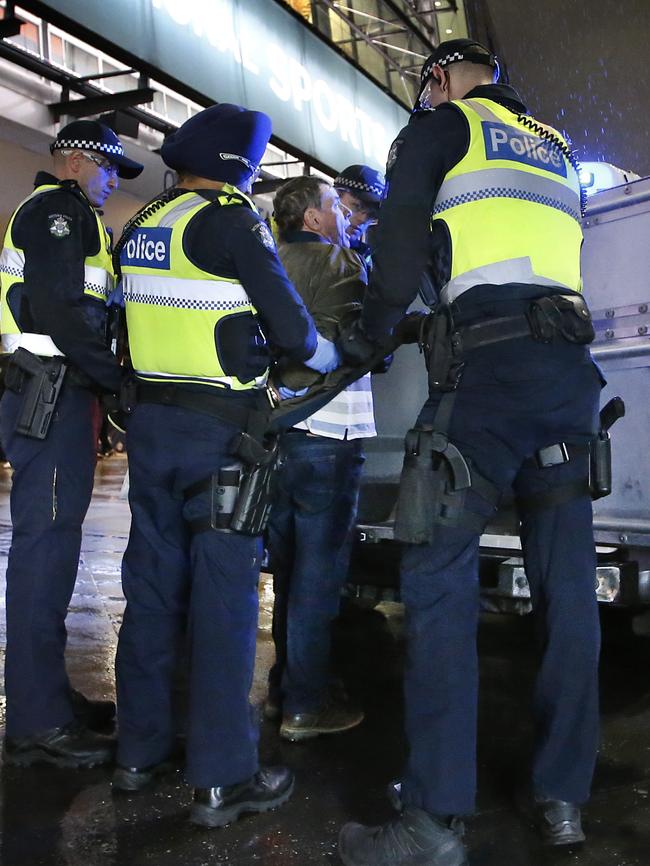 Police load a fan into a divvy van. Picture: David Caird