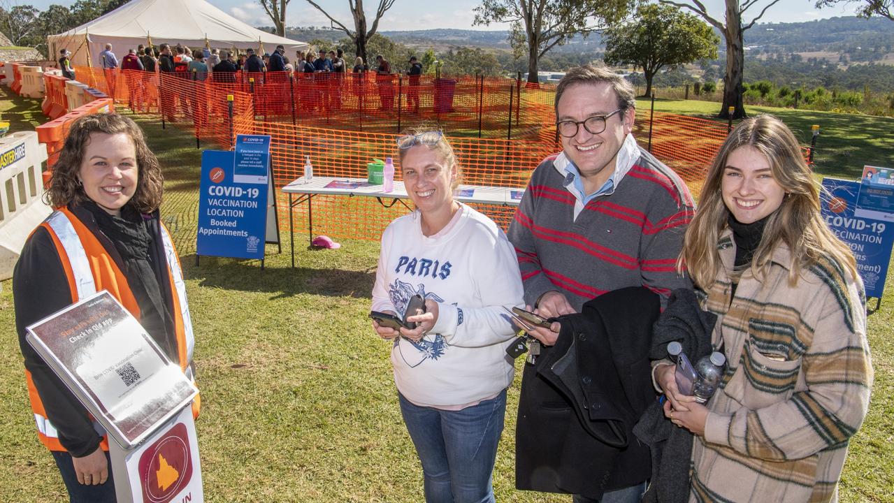 SUPER PATIENTS: Covid vaccination project team member, Monique Morgan helps Dana and Ben Gouldson and their daughter Georgia check in to the Darling Downs Covid super clinic at Baillie Henderson Hospital on Saturday. Picture: Nev Madsen.