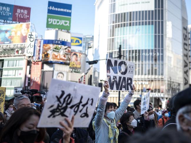 People hold placards as they gather at Tokyo's Shibuya area to protest Russia's invasion of Ukraine. Picture: AFP