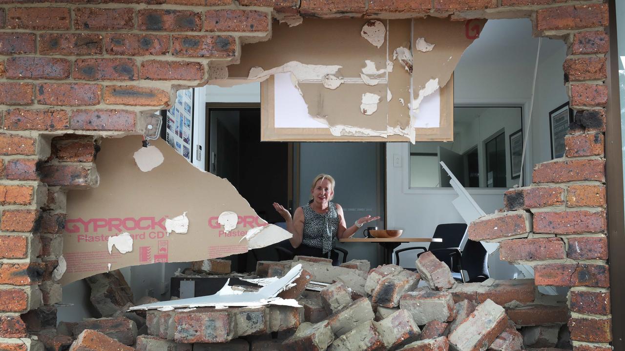 Ros Bates peers through the wall to the carpark outside her office in Mudgeeraba. Picture: Glenn Hampson