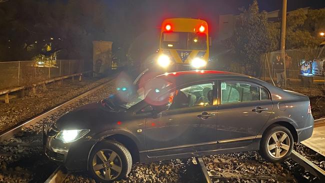 An Essendon woman was almost hit by a train after her car became stuck on the tracks in Essendon.