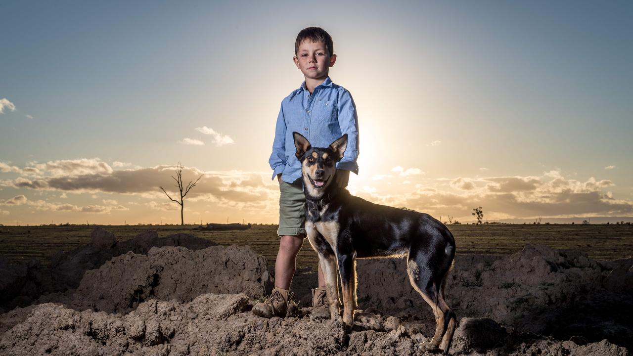 Charlie Anderson, 6, is joined by his dog Lucy as he stands on top of the dam wall in the Giffard West region of Gippsland in Victoria. February, 2019. Picture: Jake Nowakowski