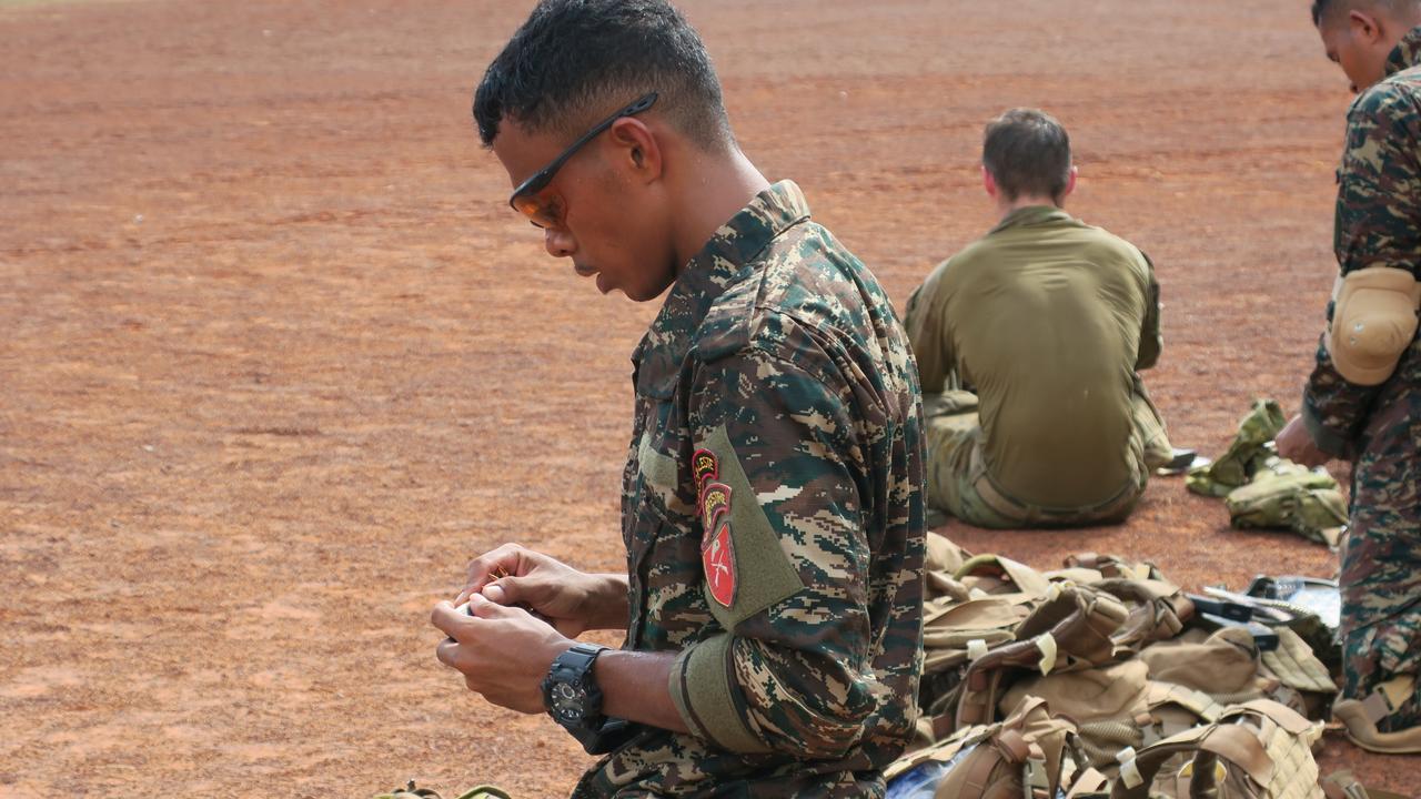 A Timorese soldier loads his magazine before the shoot.