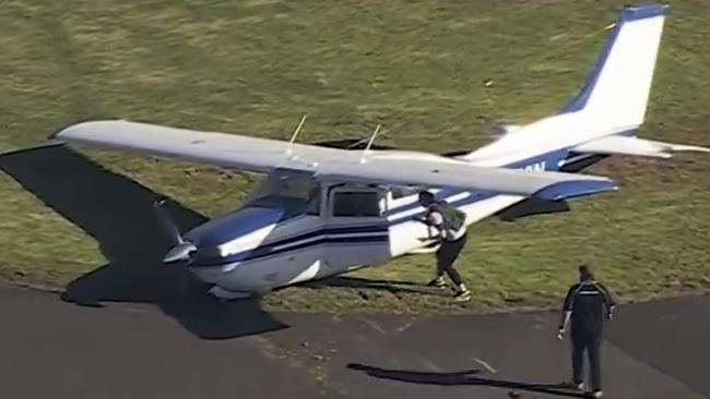 The light aircraft halted at an angle with its right wing scrapping the asphalt upon stopping.