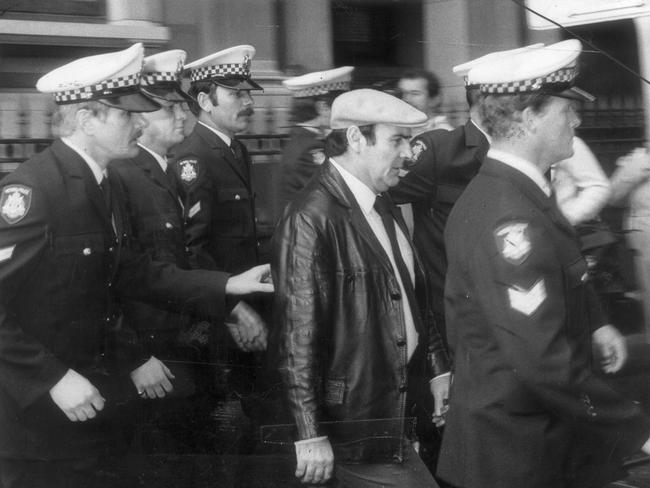 Mafia supergrass Gianfranco Tizzoni being escorted by police from the Victorian Supreme Court after pleading guilty to having conspired to murder Griffith anti-drug campaigner Donald Mackay.