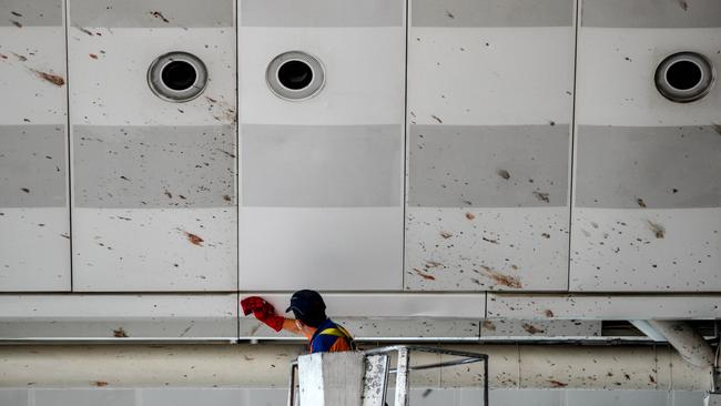 A worker cleans the blood splashed on the roof of the international departure terminal in Istanbul’s international airport after three suicide bombers. Picture: Gokhan Tan/Getty Images