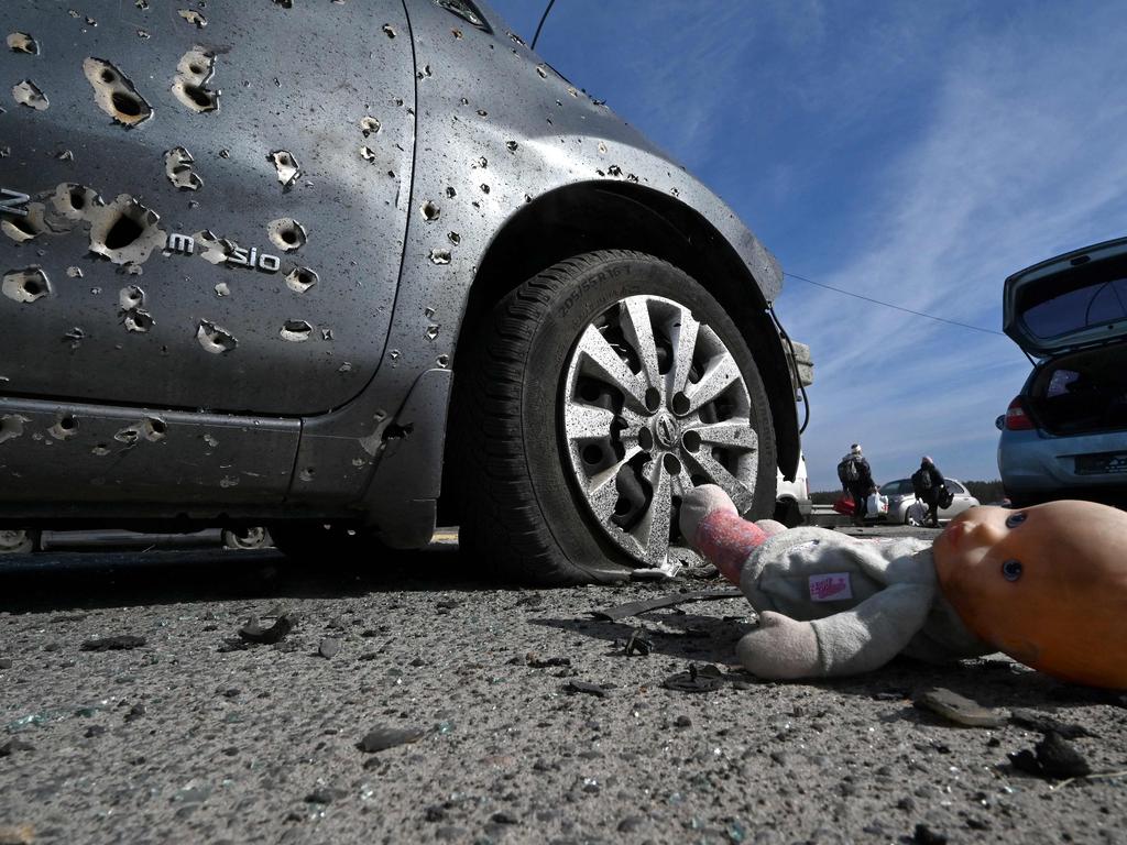 An abandoned doll next to a car riddled with bullets in Irpin, north of Kyiv. Picture: Sergei Supinsky / AFP