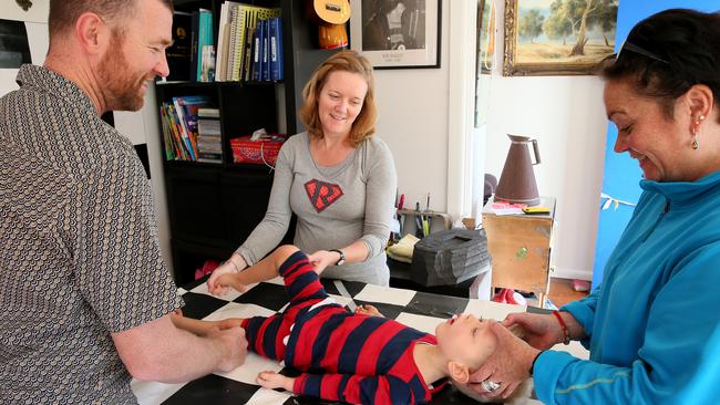 David &amp; Ina Mills give son Roki, 3, physical therapy at their Newport home, with the help of volunteer Candice West. Picture: Troy Snook