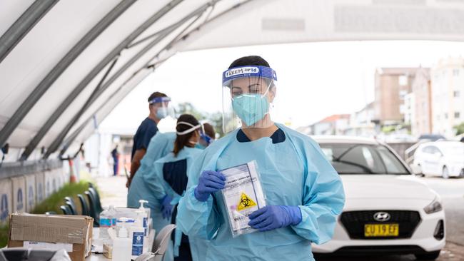 Healthcare workers administering a COVID-19 test at a drive through test centre at Bondi Beach yesterday. Picture: NCA NewsWire / James Gourley