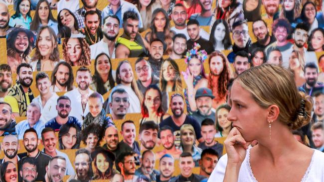 A woman views the images of the victims killed or kidnapped from the Supernova music festival during the October 7 attacks. Picture: AFP