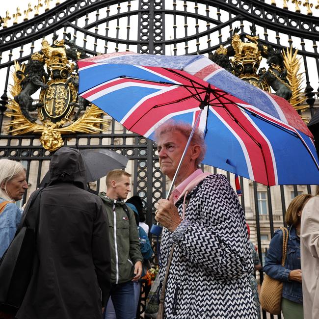 Members of the public visit Buckingham Palace in the rain to pay their respects. Picture: Getty Images