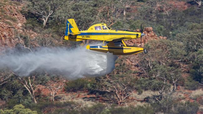 One of the 'Fire Boss' water bombers laying down a line to contain the grass fire. Picture: Mount Isa Aviation Photography