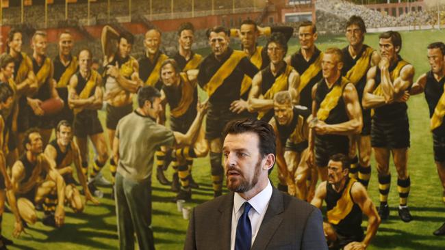 Brendon Gale stands in front of a painting of the Richmond Team of the Century, featuring Tom Hafey. Picture: Getty Images