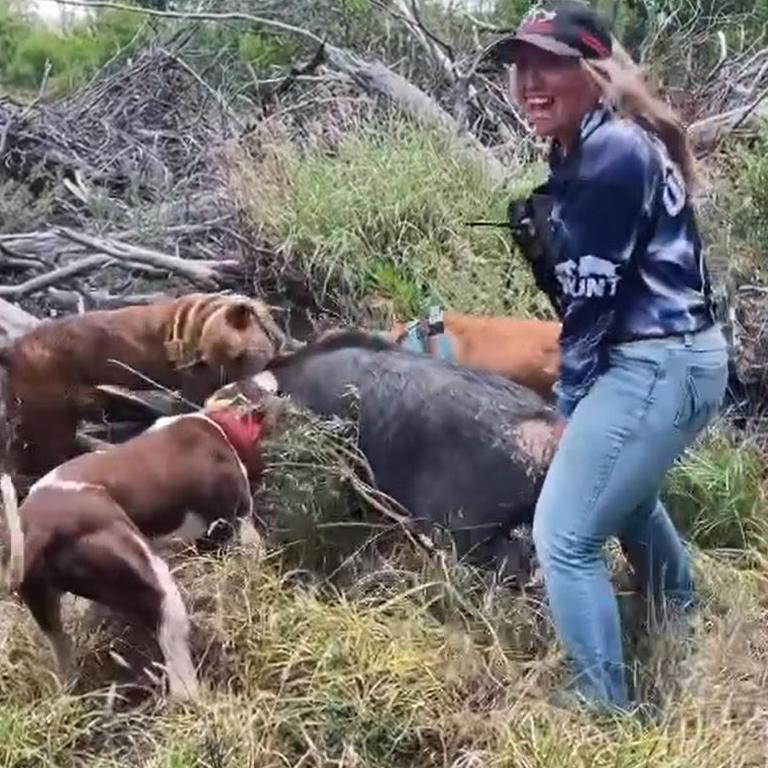 Paige smiles for the camera as her dogs kill a wild pig.